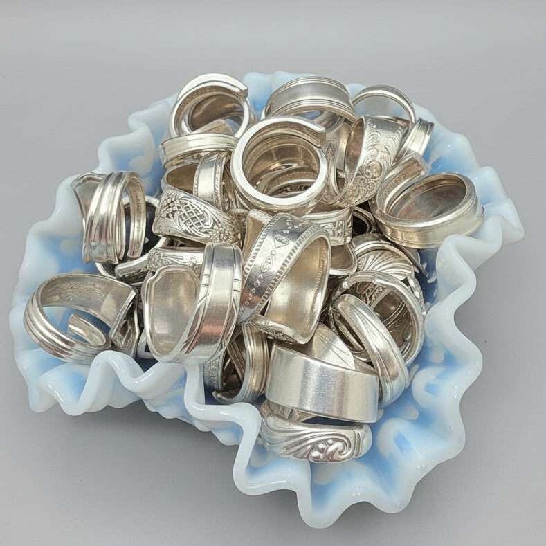 Collection of silver rings in a white dish on a bright background